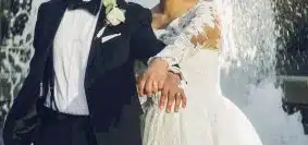 man in black suit and woman in white wedding dress