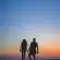 man and woman holding hands in silhouette photography